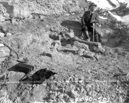 Black and white image of DeWeese with one of the dinosaur bones he found.